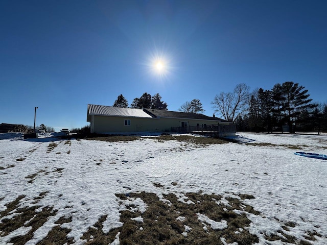 snow covered house featuring metal roof