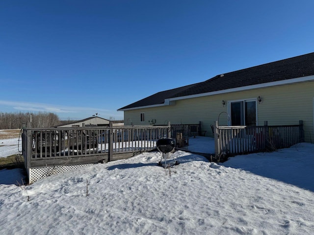 snow covered house featuring a deck