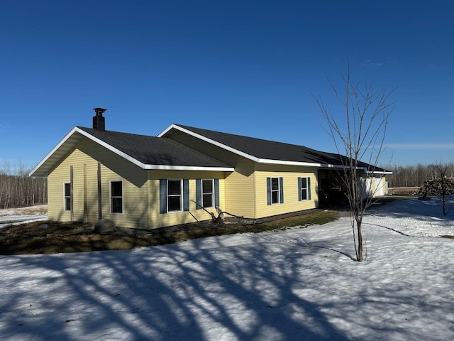 view of snowy exterior with a chimney