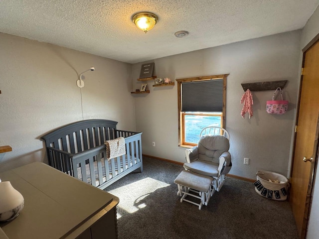 bedroom featuring carpet floors, a nursery area, baseboards, and a textured ceiling