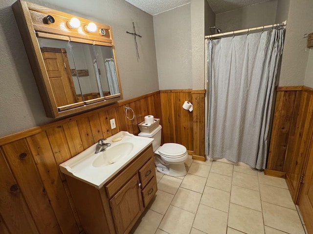 full bathroom with a shower with shower curtain, toilet, wainscoting, wooden walls, and a textured ceiling