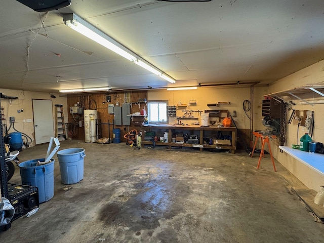 garage with electric panel, water heater, and a workshop area