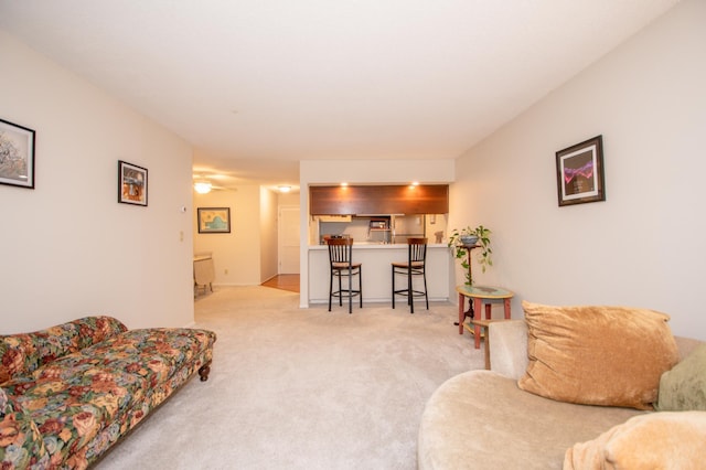 living area featuring carpet and ceiling fan