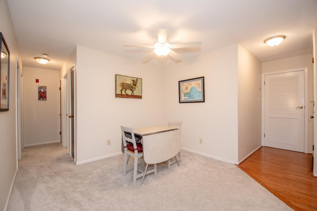 dining room with ceiling fan, baseboards, and light colored carpet