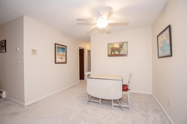 dining space featuring baseboards, a baseboard radiator, a ceiling fan, and light colored carpet