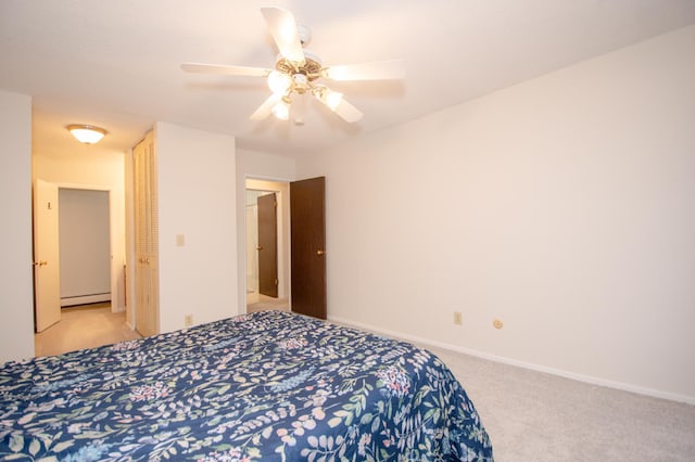 bedroom featuring light colored carpet, a baseboard heating unit, a ceiling fan, baseboards, and a closet