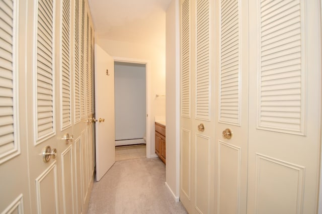 hallway featuring baseboard heating and light colored carpet