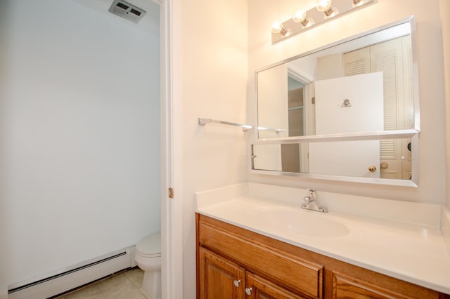 bathroom featuring a baseboard heating unit, vanity, tile patterned flooring, and toilet