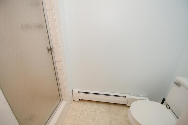 full bathroom with a baseboard heating unit, a stall shower, tile patterned flooring, and toilet