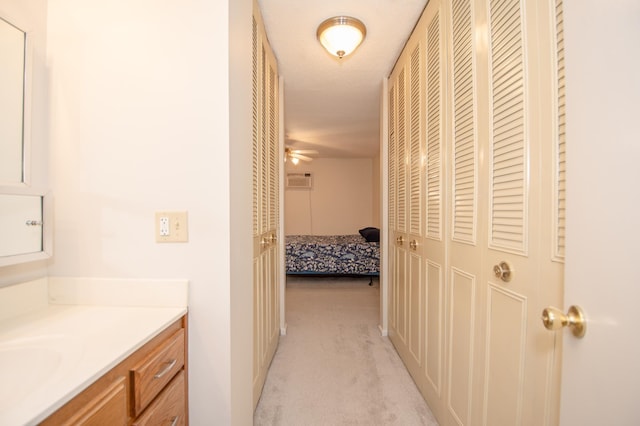 hall with a sink and light colored carpet