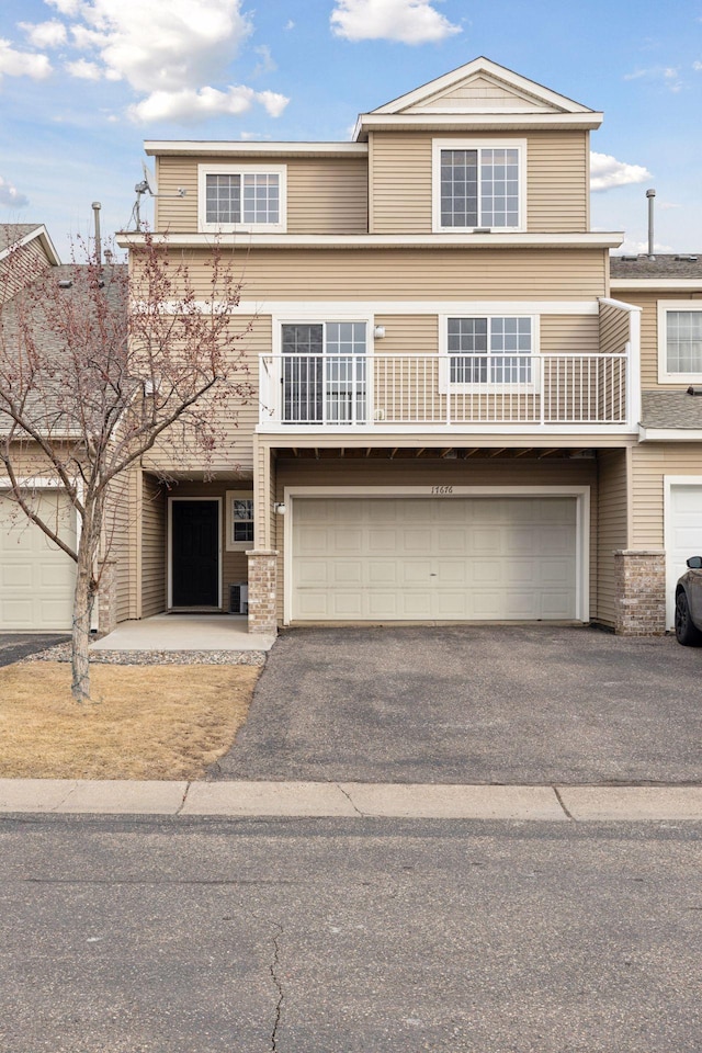 view of front of property featuring a garage, a balcony, and driveway