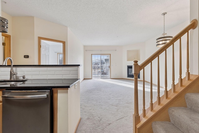 kitchen featuring a sink, dark countertops, open floor plan, carpet flooring, and dishwasher