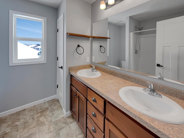 full bathroom featuring toilet, baseboards, a shower, and a sink