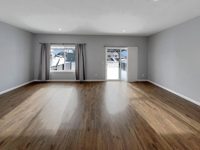 unfurnished room featuring recessed lighting, dark wood finished floors, and baseboards