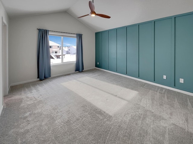 spare room featuring carpet floors, lofted ceiling, and a ceiling fan