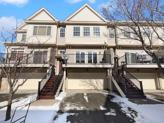 townhome / multi-family property featuring an attached garage, driveway, and stairs