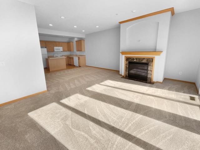 unfurnished living room featuring recessed lighting, light carpet, a fireplace, and baseboards