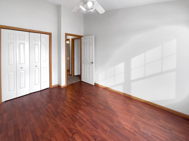 unfurnished bedroom featuring ceiling fan, a closet, wood finished floors, and baseboards