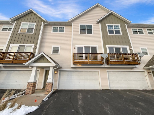 view of property featuring driveway, board and batten siding, and an attached garage