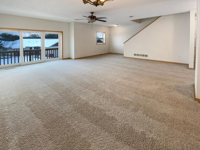 unfurnished living room featuring baseboards, visible vents, ceiling fan, and carpet flooring