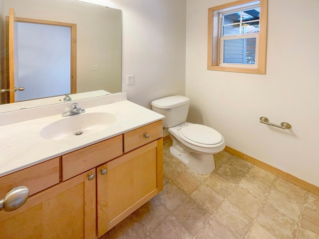 bathroom featuring toilet, baseboards, and vanity