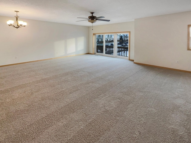 unfurnished living room featuring ceiling fan with notable chandelier, a textured ceiling, carpet, and baseboards