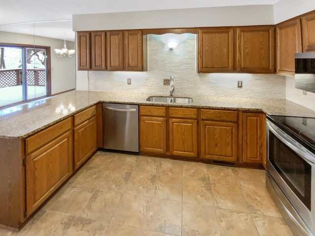 kitchen with a sink, appliances with stainless steel finishes, backsplash, light stone countertops, and brown cabinetry