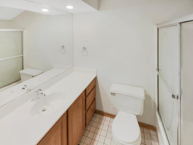 bathroom featuring toilet, vanity, and a shower with shower door