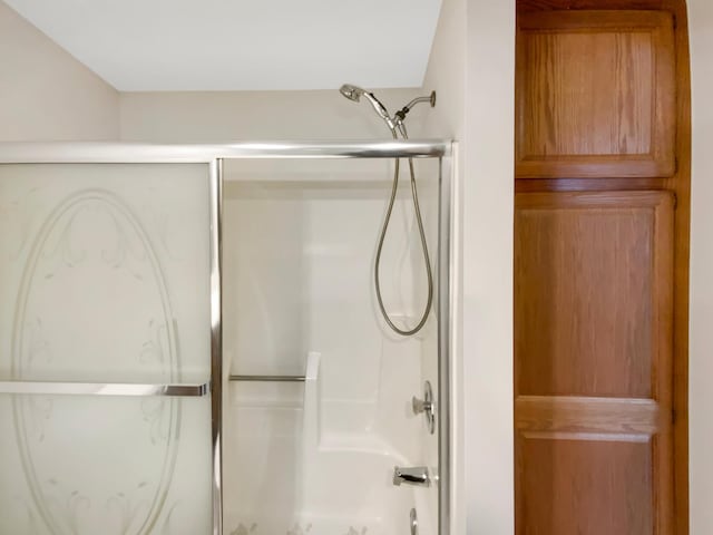 bathroom with bath / shower combo with glass door