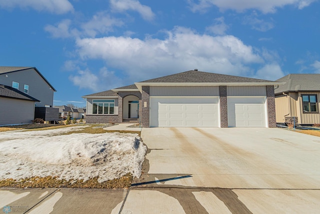 view of front of property with concrete driveway, brick siding, an attached garage, and roof with shingles