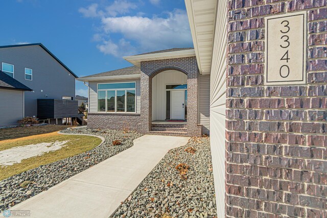 view of exterior entry featuring brick siding