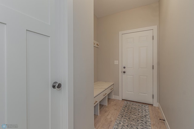 mudroom with light wood finished floors and baseboards