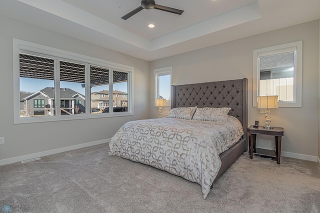 carpeted bedroom with recessed lighting, a ceiling fan, visible vents, baseboards, and a tray ceiling