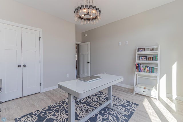 office area featuring light wood-style flooring, baseboards, and a notable chandelier