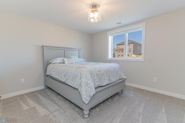 bedroom featuring light colored carpet and baseboards