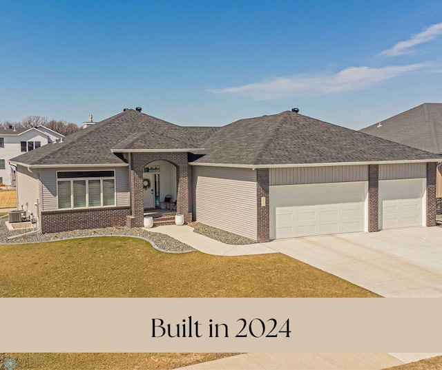 ranch-style home with an attached garage, a front yard, driveway, and brick siding