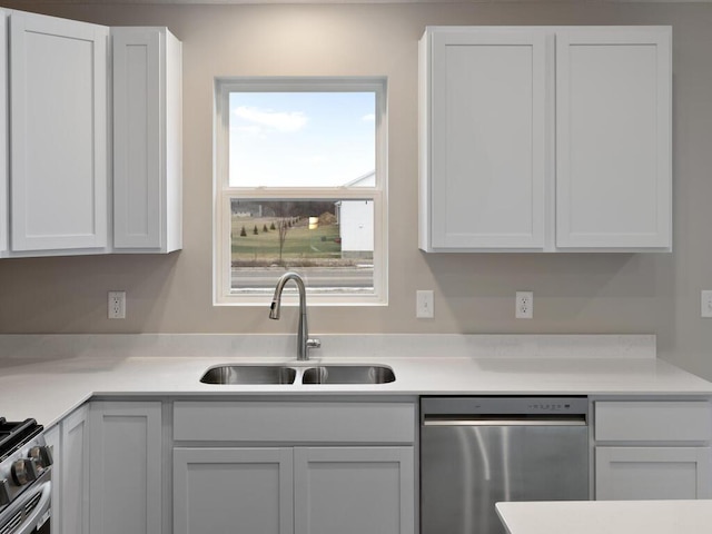 kitchen with light countertops, a sink, white cabinets, and stainless steel appliances