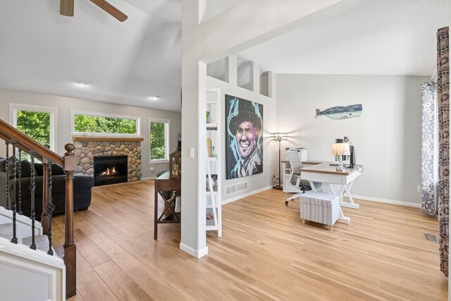 4514 Mcallister Ave NE, Saint Michael, MN 55376 - office area featuring a stone fireplace, light wood-style floors, a ceiling fan, baseboards, and lofted ceiling