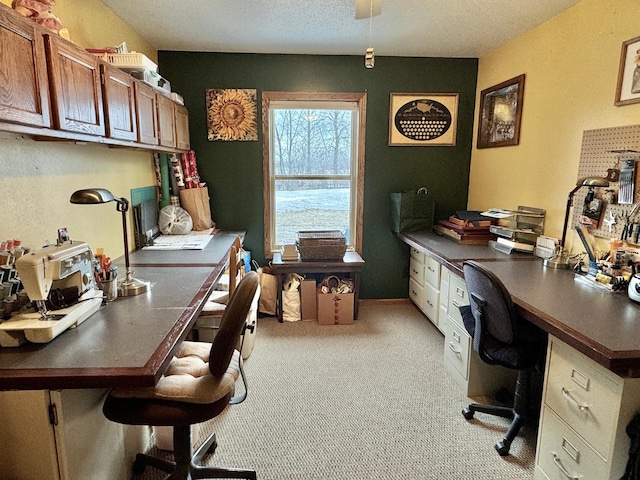 office with light carpet, built in desk, and a textured ceiling