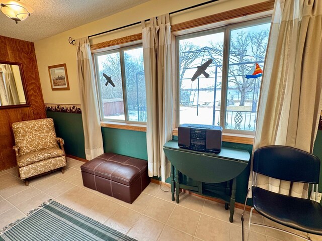 living area with a textured ceiling and tile patterned flooring