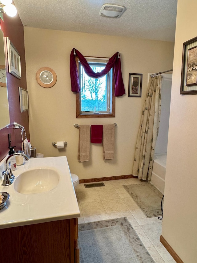 full bathroom with tile patterned flooring, visible vents, a textured ceiling, and vanity