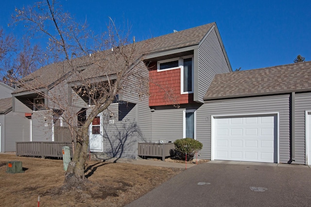 view of front of property with a garage, driveway, and a shingled roof