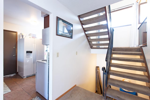 stairs featuring tile patterned flooring and washer / clothes dryer