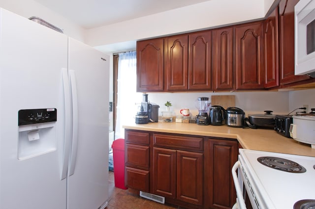 kitchen featuring light countertops, white appliances, and visible vents