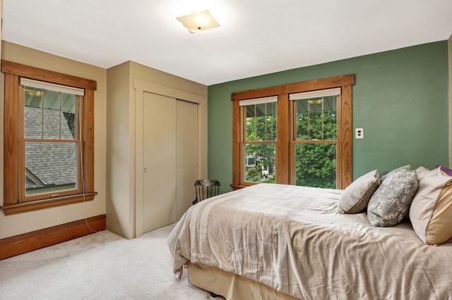 carpeted bedroom featuring a closet and baseboards