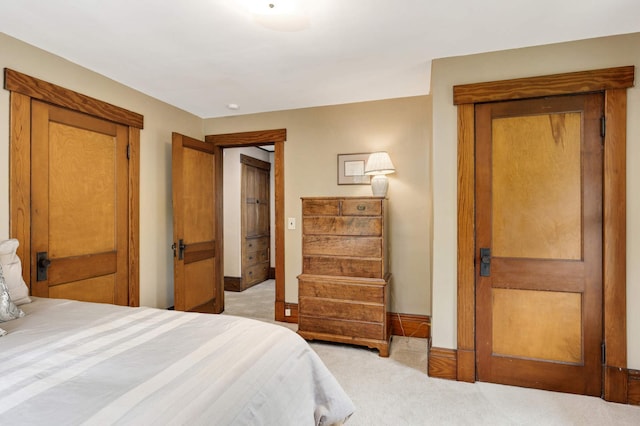 bedroom featuring light carpet and baseboards