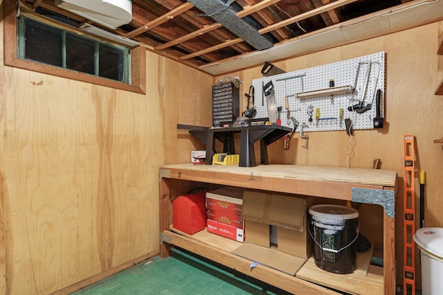 below grade area with wood walls, a workshop area, and tile patterned floors