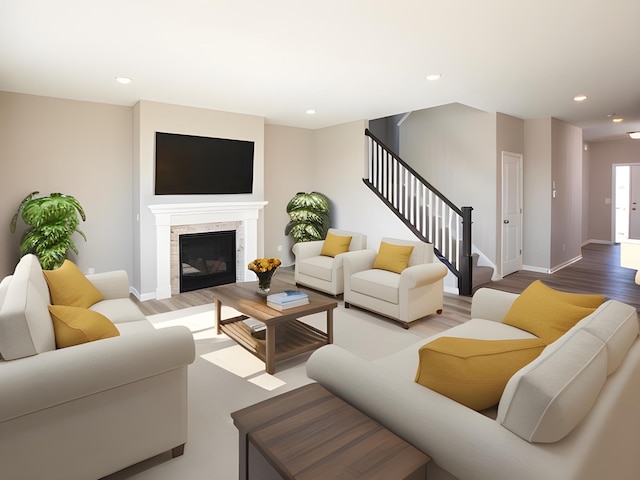 living area with baseboards, stairs, recessed lighting, wood finished floors, and a glass covered fireplace