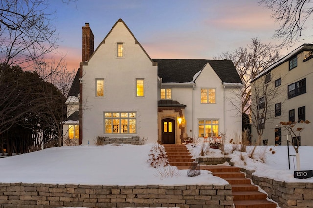 view of front of home featuring a chimney and stucco siding