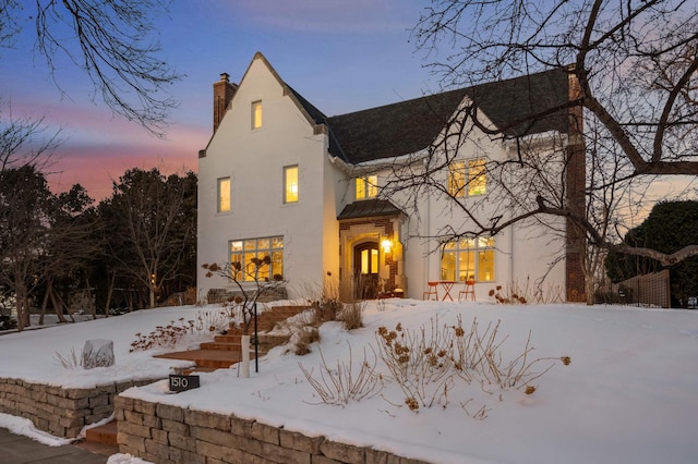 view of front of home with a chimney and stucco siding